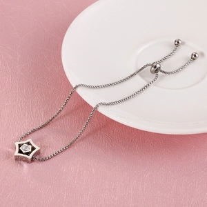Macro shot of silver star pendant with crystals and adjustable bolo chain on white porcelain