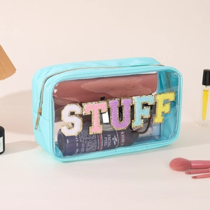 Detail of blue nylon makeup bag with clear PVC and glittery STUFF lettering