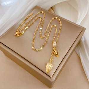 Elegant gold titanium steel leaf pendant necklace with zircon accents on jewelry box