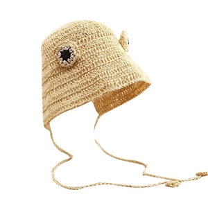 Close-up of beige woven straw hat featuring cute frog eyes design and windproof strap