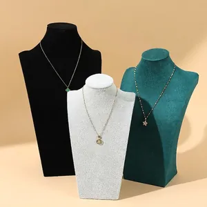 Three elegant gold necklaces with clover, round, and star pendants on velvet busts