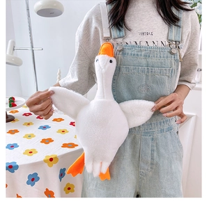 White goose plush bag on model showing adjustable strap in a cozy home setting