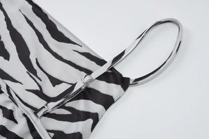 Detailed view of adjustable spaghetti strap and zebra print fabric on this summer top