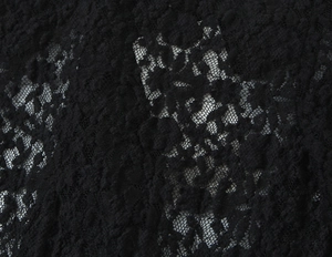 Close-up of black floral lace fabric showing intricate patterns and mesh texture details