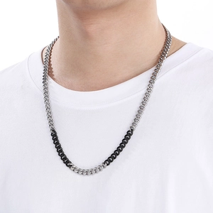 Detail of silver and black two-tone Cuban link necklace on a model neck