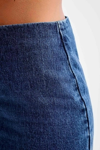 Vue macro détaillée de la texture du denim bleu foncé et des coutures de la taille