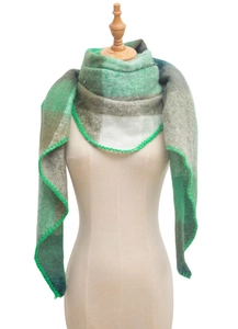 Detail view of green plaid triangular scarf with decorative blanket stitched edges