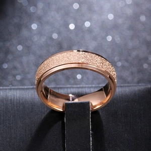 Macro shot of 6mm matte rose gold titanium ring with polished edges and grainy texture