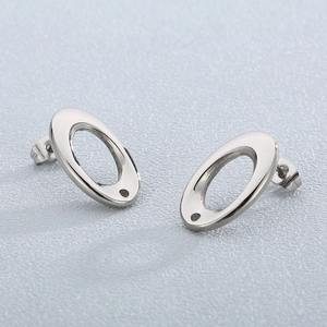 Vue macro de boucles d'oreilles ovales argentées évidées avec trous pour bijoux DIY