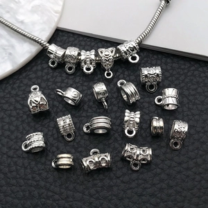 Silver alloy bead spacers and pendant connectors on black leather background