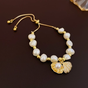 Detail of freshwater pearl shell bracelet with zircon tassels and adjustable gold chain