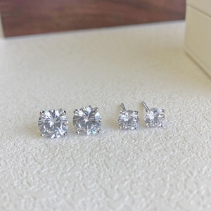 Macro view of two pairs of S925 sterling silver stud earrings with clear CZ stones