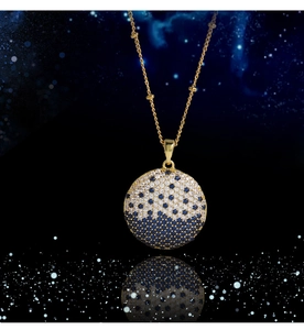 Macro shot of planet pendant with pavé set crystals on a gold bead chain over starry sky