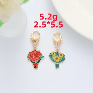 Detailed close-up of rose and sunflower enamel keychains with golden heart clasps