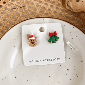 Close-up of reindeer and green bell Christmas studs on a white ceramic plate