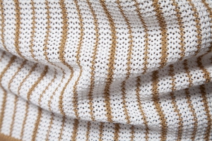 Detail of white knitted polo fabric with brown stripes and breathable hollow mesh texture