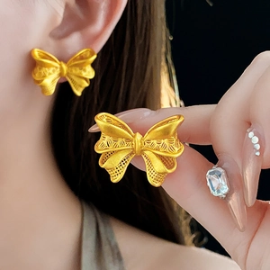 Close-up of 18K gold plated hollow bow earrings showing detailed craftsmanship and luster