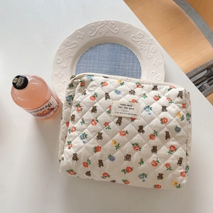 Detailed view of quilted cotton cosmetic bag with cute bear and floral prints