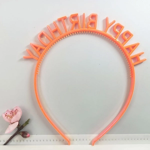 Close-up of orange plastic headband featuring Happy Birthday lettering design