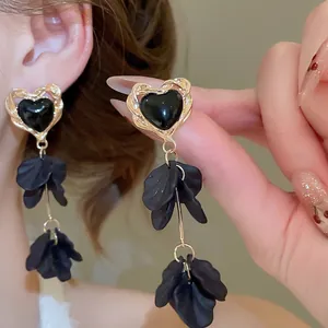 Elegant gold heart earrings with black acrylic petals and tassels for a French vintage look