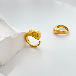 Minimalist golden curved open ring featuring a smooth polished organic water drop design