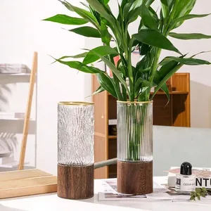 Modern glass vase set with textured stripes, wood base, and green plants decor