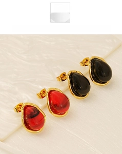 Detail view of water drop earrings in red and black resin with textured gold finish