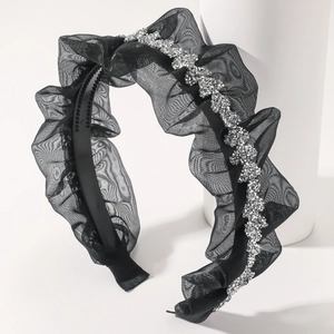 Close-up of black mesh headband with shiny silver rhinestone accents and elegant texture