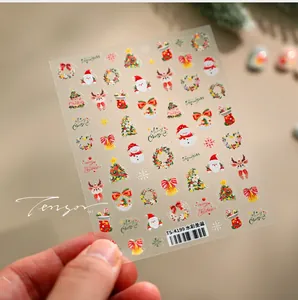 Detail shot of watercolor Christmas nail stickers with Santa Claus and reindeer motifs