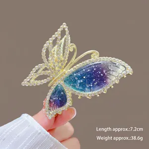 Detail view of 7.2cm gold fish tail hair claw with deep sea blue butterfly wing texture