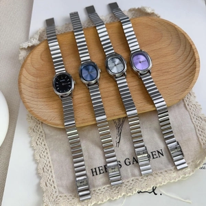 Close-up of four NAIDU women's watches with oval dials and metal chain bracelets