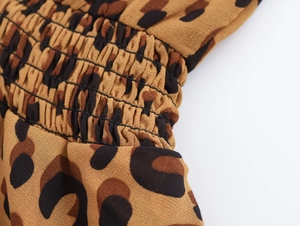 Detail of leopard print dress waist showing elastic band and light leopard fabric
