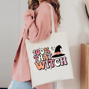 Halloween canvas tote bag with 100% That Witch print and witch hat design on a model