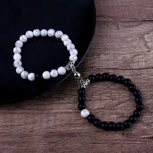 Detail of couple magnetic bead bracelets with black and white heart stone charms