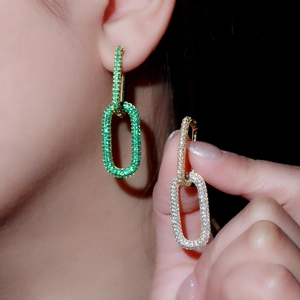 Macro view of geometric link earrings with green and white micro-pave cubic zirconia