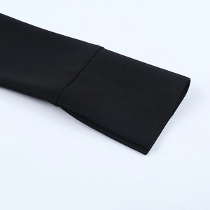 Vue détaillée de la couture et de la texture du poignet de la robe noire en gros plan