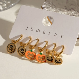 Detailed view of 6-piece Halloween earring set with gold skulls and orange pumpkins