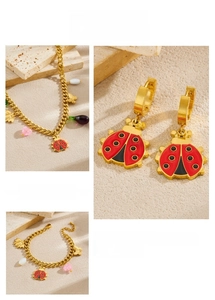 Detail of ladybug pendant and gold Cuban chain necklace with heart charms and enamel