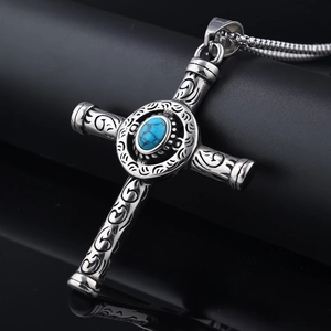 Detailed macro view of vintage silver cross necklace with turquoise stone and ornate carving