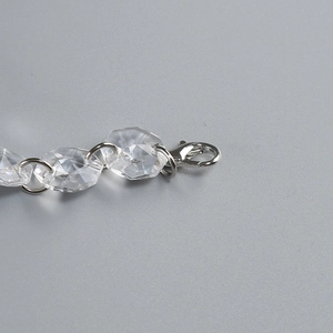 Detail of multi-faceted clear crystal beads with silver metal rings and lobster clasp