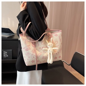 Detailed view of the large capacity casual tote bag featuring stylish graffiti prints and a cute rabbit charm.