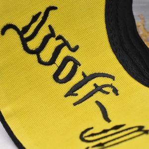 Close-up of premium black embroidery on yellow cotton twill fabric of the baseball cap
