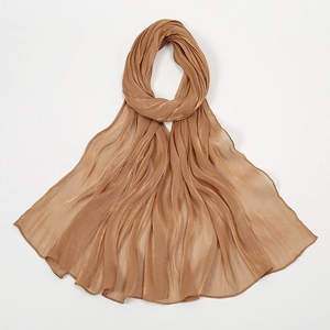 Detail eines goldbraunen Schals aus Chiffon mit Metallic-Glanz und eleganter Wellenstruktur