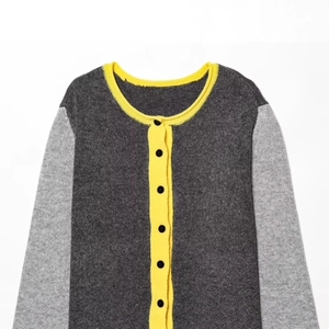 Knit cardigan in color-block dark grey and light grey with yellow ribbed trim and buttons