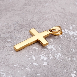 Detailed side view of a gold cross pendant resting on a natural grey stone texture