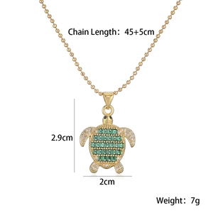 Detail shot of 18K gold turtle necklace with green stones and precise dimensions