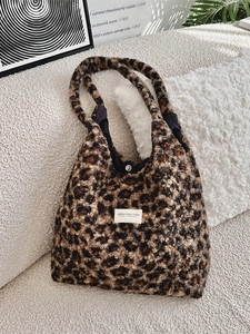 Chic leopard print faux shearling tote bag for autumn and winter on a cozy sofa