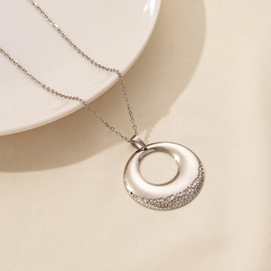 Macro detail of silver O-chain necklace with hammered texture hollow circular pendant