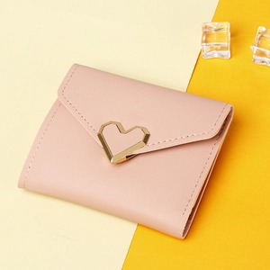 Close-up of pink leather wallet with gold heart buckle and envelope flap detail