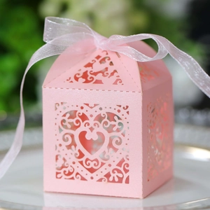 Detailed view of pink laser-cut heart wedding favor box with elegant white ribbon bow